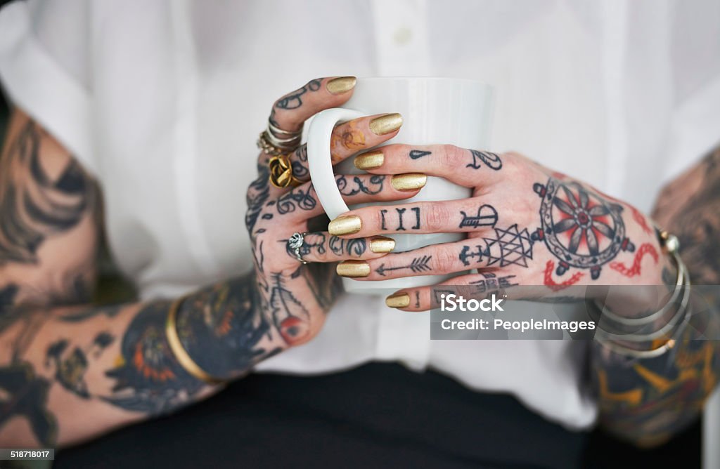 She loves her tattoos Shot of an unrecognizable tattooed businesswoman holding a mug Tattoo Stock Photo