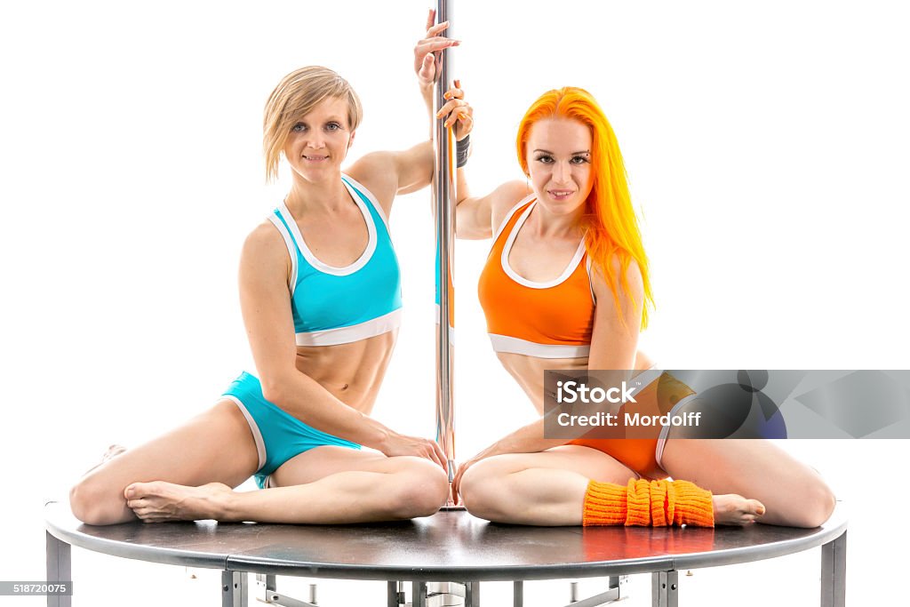 Two women sports dancers Two female pole dancers sitting together near the pole on white background 30-39 Years Stock Photo