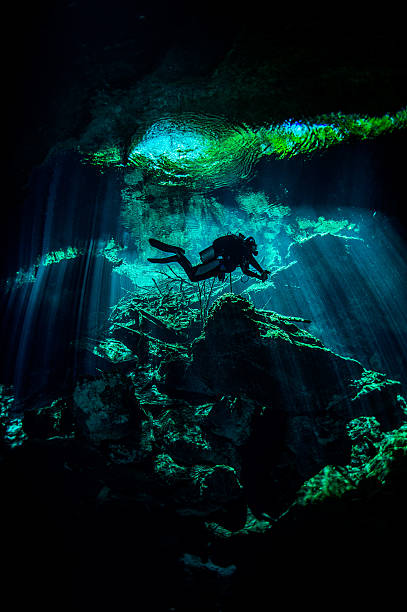 Exploring xenotes Scuba diver exploring the underwater xenotes. puerto aventuras stock pictures, royalty-free photos & images