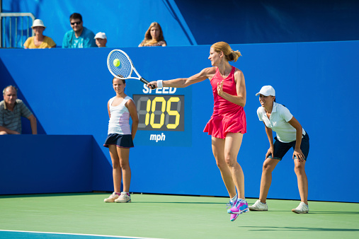 Female tennis player, spectators in the background.