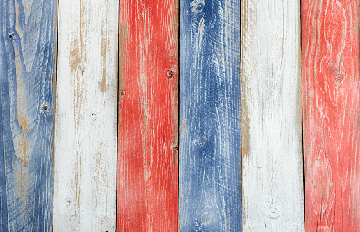 Stressed wooden boards painted red, white and blue for patriotic concept of United States of America. Layout in vertical format.