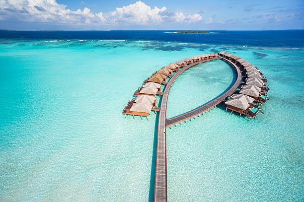 bird's eye view luxury overwater villas aerial view of luxury overwater villas in tropical lagoon of indian ocean atoll photos stock pictures, royalty-free photos & images