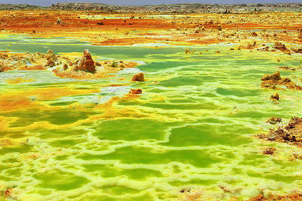 Green pond-Dallol mountain rising 50-60 ms.over Lake Karum-Assale. Danakil-Ethiopia. 0332 Green pond-Dallol mount rising over the surrounding flats of Lake Karum-Assale. Colored deposits of sylvite -KCL- carnallite -KMGCL3.6(H2O)- and kainite -KMG(SO4)CL.3H20. Danakil-Afar region-Ethiopia dallol ethiopia stock pictures, royalty-free photos & images