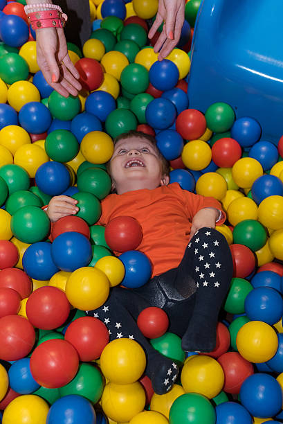 istock Little boy laughing at ball pool 518728240