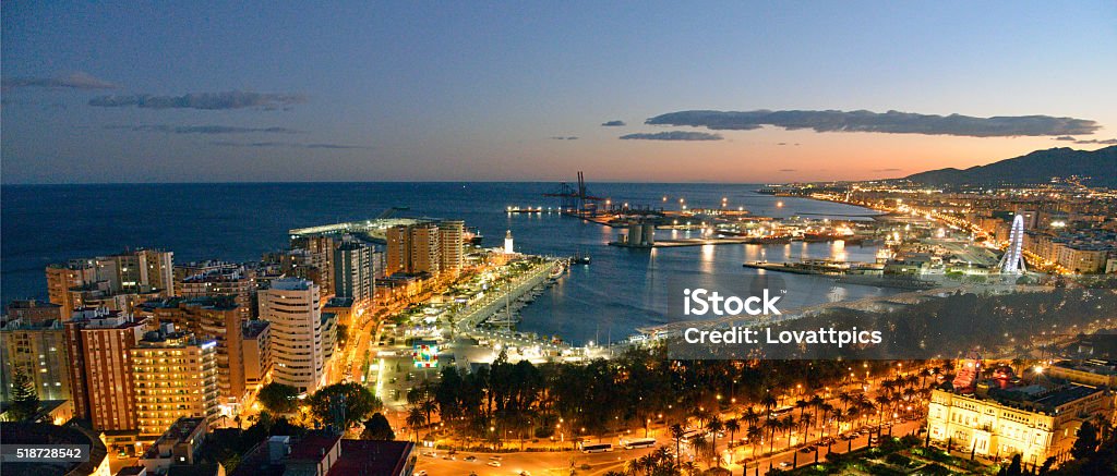Malaga city and port area at night. Malaga city and Port area taken from above. Taken on  clear evening under a blue sky just after sunset. The buildings are partly lit by the street lighting and partly by ambient light. Andalusia Stock Photo