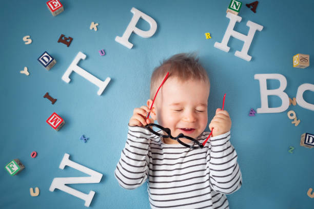 istock One year old child lying with spectacles and letters 518730064