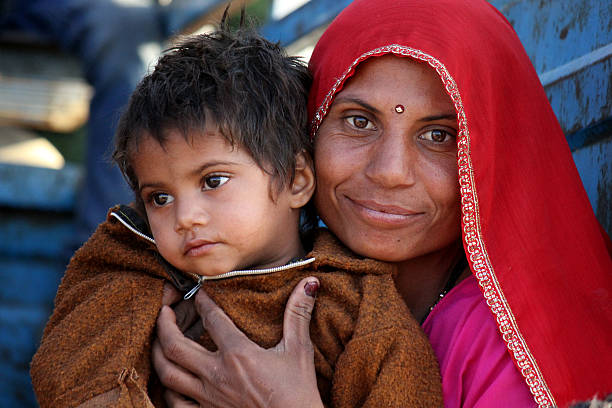 Pushkar, India, November 28 2012: A beautiful Indian Mum with her son, looking at the camera. Image taken in the street