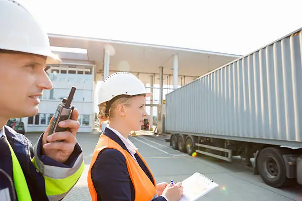 Photo of Male and female workers working in shipping yard