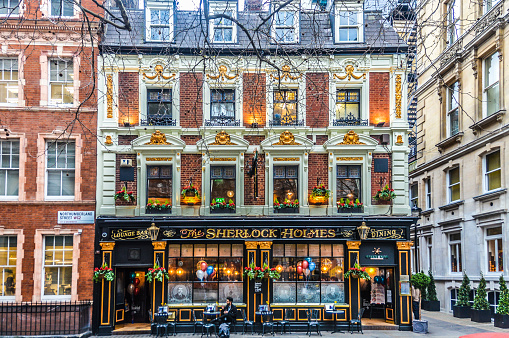 London, UK - March 19, 2016: People outside the Sherlock Holmes Pub in London, England. It was so named in 1957 when it became home to Sherlock Holmes exhibits from the Festival of Britain.