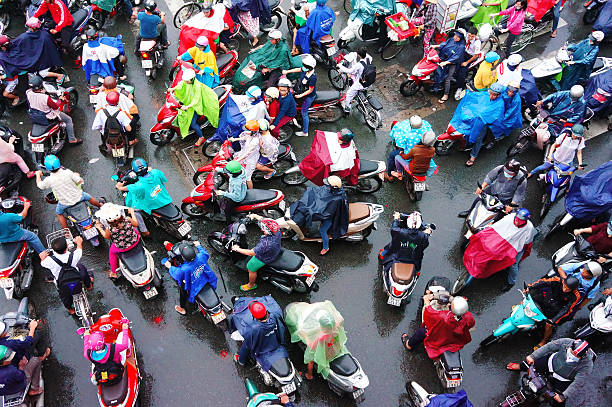 Ho Chi Minh city, Viet Nam - October 6, 2014:  Impression, colorful scene of Asia city in rush hour after rain evening, crowd of Vietnamese people wear raincoat, on motorbike, crowded on street, Vietnam, Oct6,2014
