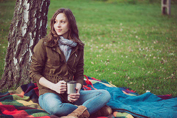 istock Brunette woman resting under a tree outdoor. 518737134