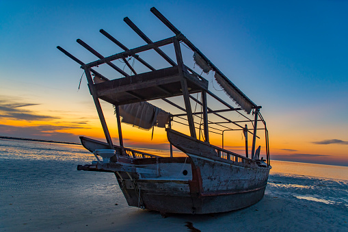 Old boat on the beach during sunset 