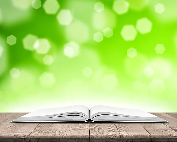 libro aperto su legno flessioni su sfondo sfocato verde chiaro - open teaching book wood foto e immagini stock