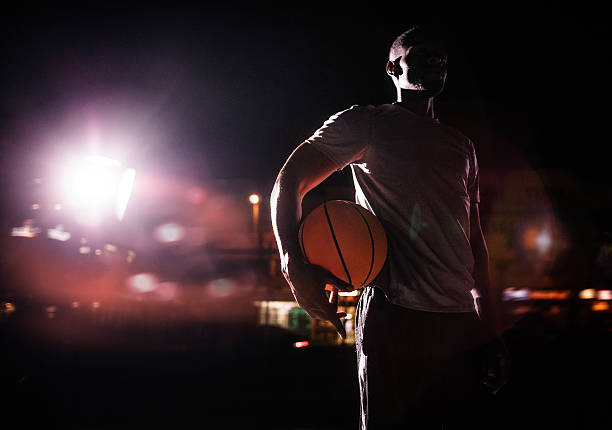masculino jogador de basquete com bola no quadril em noite - street light dark street men - fotografias e filmes do acervo