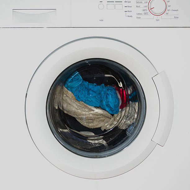Washing machine full of dirty clothes stock photo