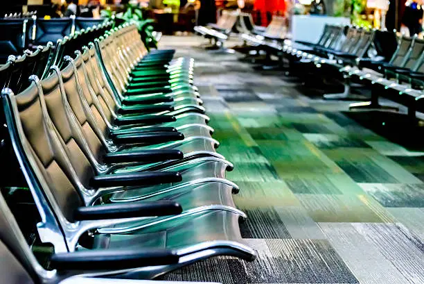 Photo of empty airport seating - typical black chairs in boarding waiting