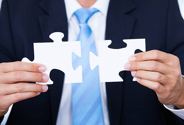 istock Businessman Holding Jigsaw Puzzle 518752785