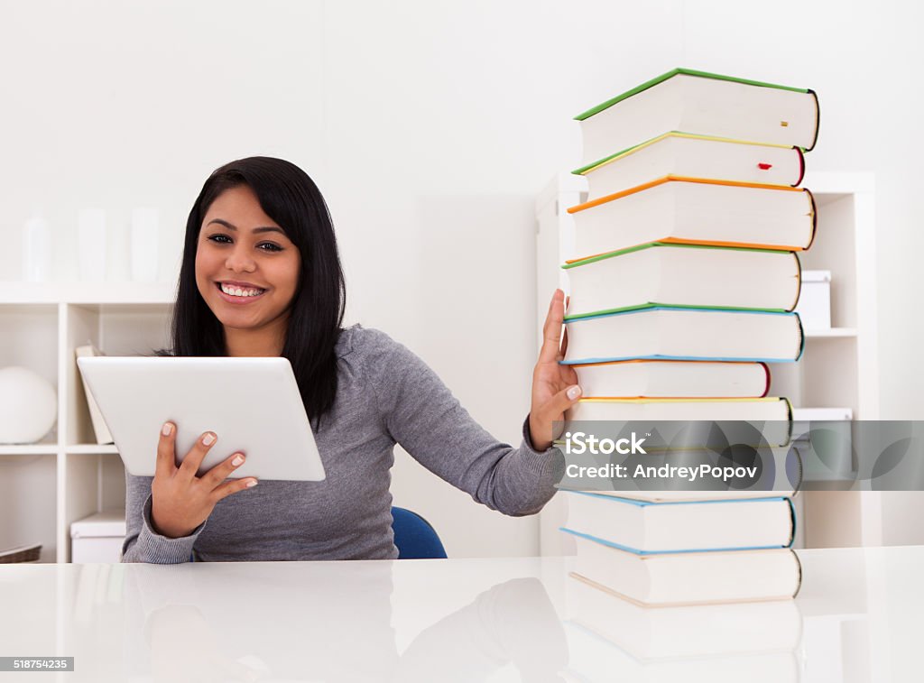 Woman Avoiding Books And Using Tablet Young Woman Avoiding Books And Using Tablet At Home Book Stock Photo