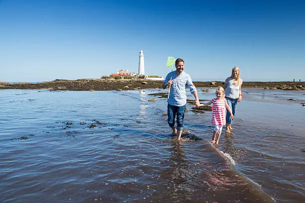 Photo of Family Walking Through the Sea