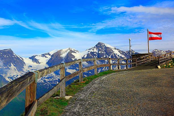 österreichische flagge, hohensalzburg fortress alpine gipfel, dramatischen sonnenuntergang-grossglockner - austrian flag stock-fotos und bilder