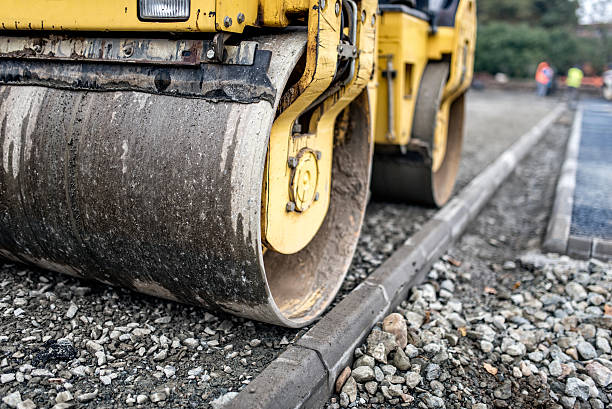istock Heavy tandem road roller compacting layers of gravel 518756786