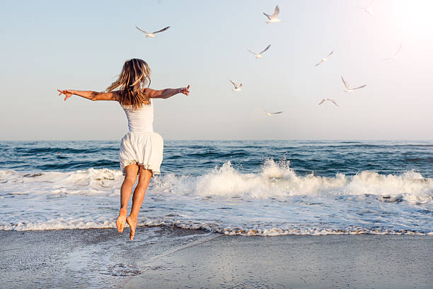 istock Beautiful girl  jumping on sea 518757671