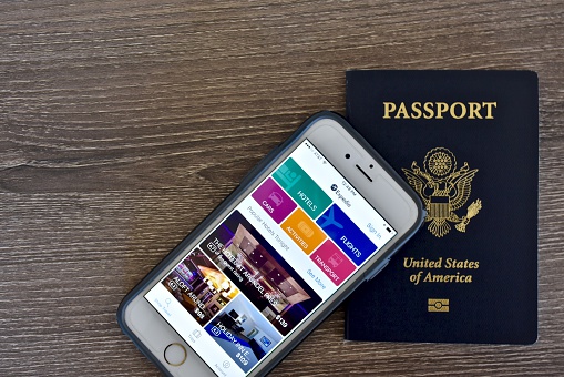 Odenton, USA - April 3, 2016: An Apple iPhone 6s displaying the Expedia application homepage on the screen while laying next to an American passport.