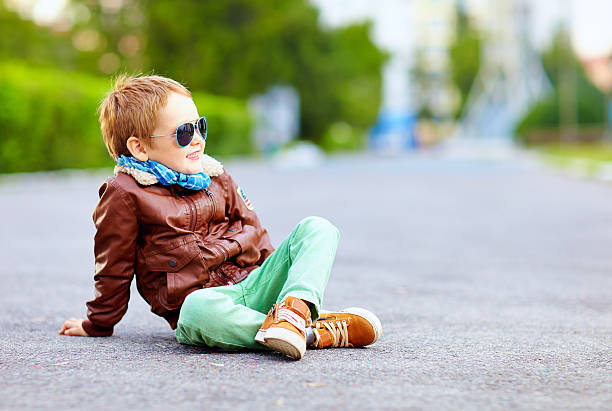 istock stylish boy in leather jacket posing on the ground 518757841