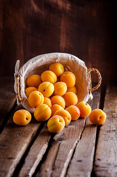 istock Apricots in basket on wooden table 518761376