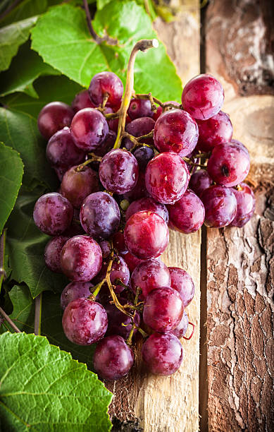 istock Red grapes on wooden table 518761538