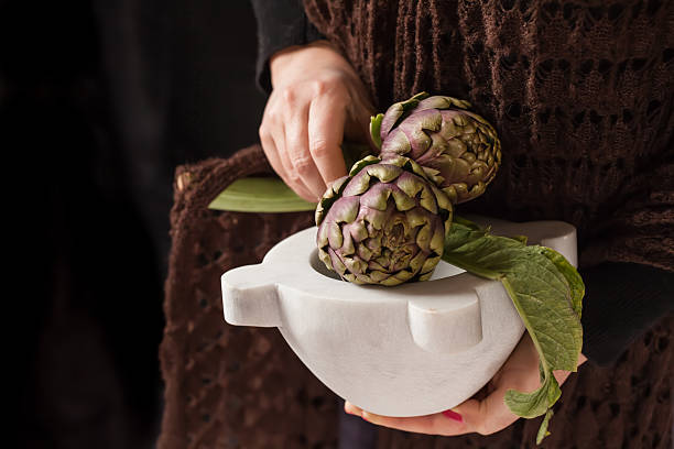 istock Woman Hands Holding Artichokes 518763538