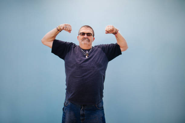 Heavy set older man showing his muscles