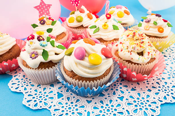 istock Birthday cupcakes with balloons on a blue background 518775612