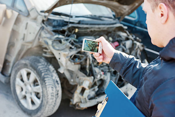 istock Insurance agent photographing car damage for claim form 518775648