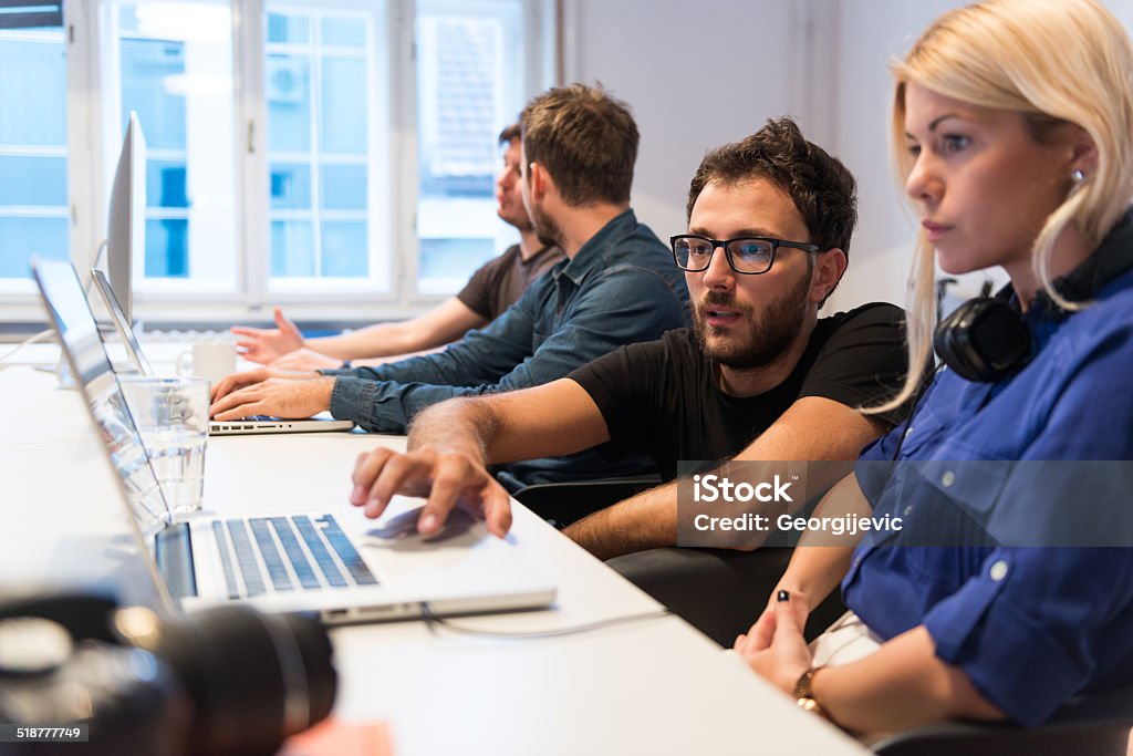 Start-up Team Young team of creative people working in office. A Helping Hand Stock Photo