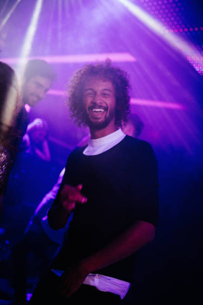 istock Handsome young guy dancing eith friends in a night club 518779400