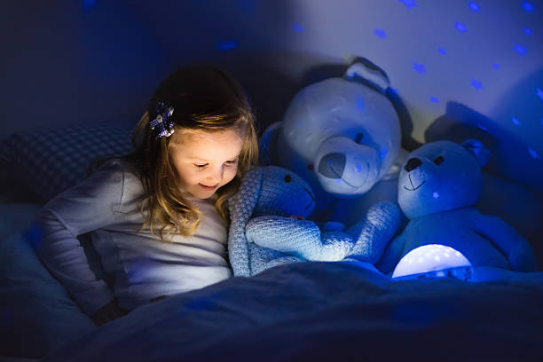 istock Little girl reading a book in bed 518780264