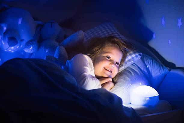 istock Cute little girl reading a book in bed 518780794