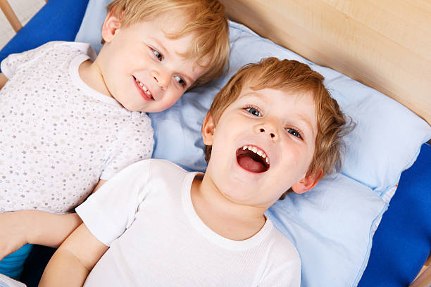 istock Two little toddler boys having fun in bed 518797595