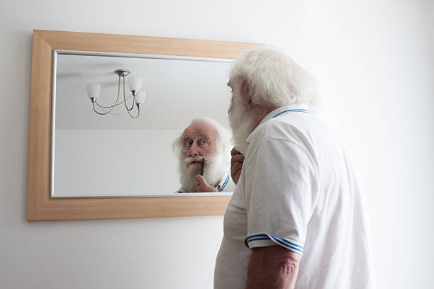 istock senior bearded man grooms moustache in mirror 518798891