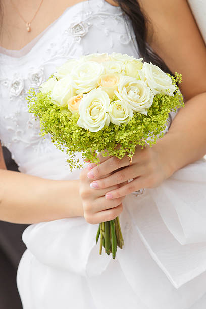 istock Wedding bunch of flowers in hands  the bride 518799293