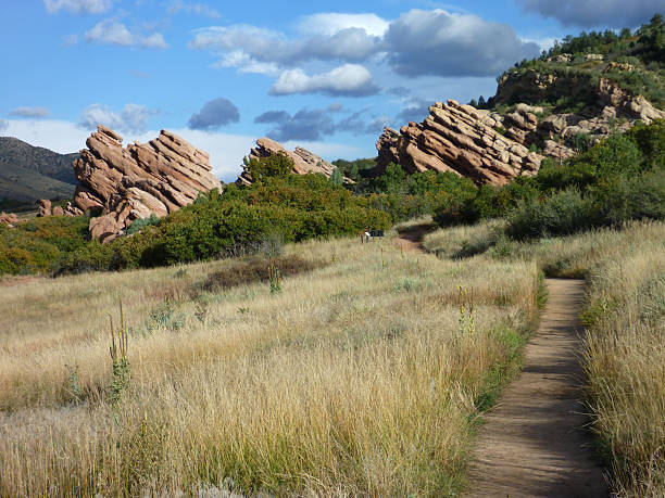 Trail through beautiful sandstone spires Colorado A trail for hiking, running and mountain biking leads north towards a cloud filled sky past beautiful and dramatic sandstone spires, part of the South Valley Park near Ken Caryl, Colorado. morrison stock pictures, royalty-free photos & images