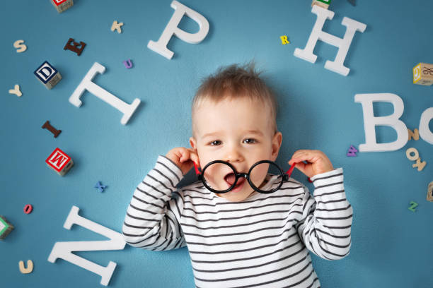 istock One year old child lying with spectacles and letters 518800094