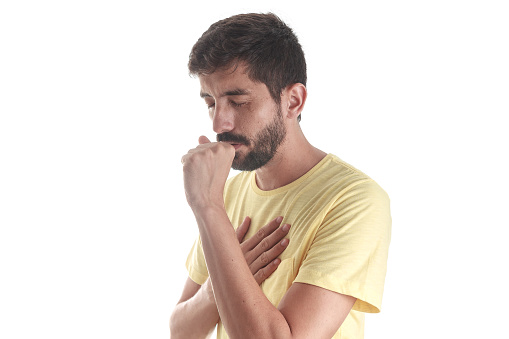 Respiratory disease. Young man coughing on white background
