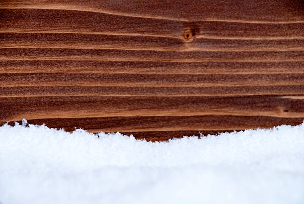 Snow in front of a Wooden Background as Winter or Christmas Background with Copy Space