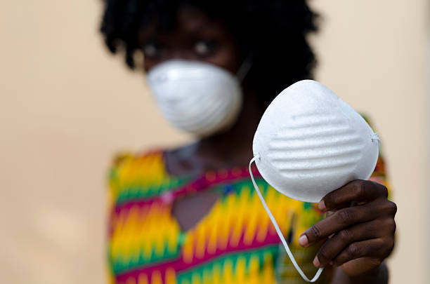 istock Stop Ebola Now Helping Hand Symbol: Nurse Handing Face Mask 518815775