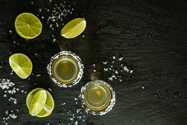 istock Gold tequila shots on rustic wood background 518816232