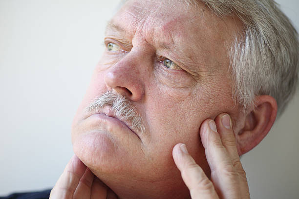 istock Older man with facial pain 518816255