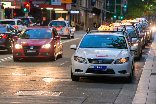 Sydney, Australia - November 10, 2015: Taxi queued for passengers in Sydney CBD at night. The state of New South Wales is served by a fleet of around 6000 taxis. The industry employs over 22,700 taxi drivers.