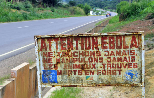 Attention, Ebola! Makoua, Congo,- September 27, 2013: A sign warns visitors that area is an Ebola infected. Signage informing visitors that they are entering the ebola infected area. ebola stock pictures, royalty-free photos & images